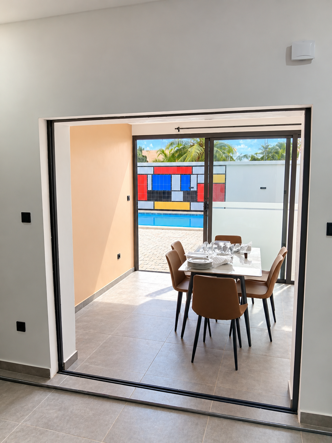 Espace intérieur lumineux ouvrant par de larges baies vitrées sur la piscine et la fresque Mondrian